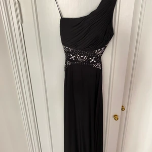 Balklänning - Som ny. Kemtvättad. Använd ett fåtal gånger. I svart med pärlor, öppen i ryggen. Passar storlek 36.