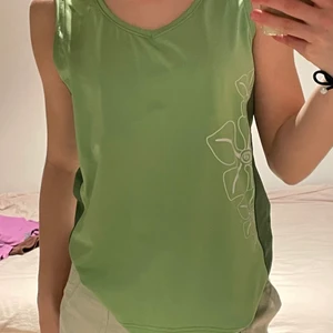 Grönt linne - Ett grönt tränings isch sommar linne. Linnet är aldrig använt och är i fint skick. Fina blommor och är inte genomskinlig. Linnet har även dubbeltyg så man behöver inte ha något under. Passar även mig som har xs/s. Mysigt till sommaren.
