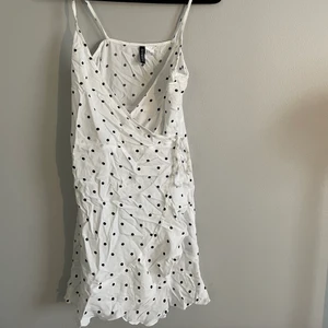 Sommarklänning, 36 - Omlottklänning vit med svarta prickar och knyt. Nyskick