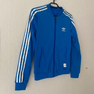 Adidas tracksuit (överdel) - Adidas tracksuit överdel. Lappen finns ej kvar, men uppskattar att den är strl S då jag brukar ha det.