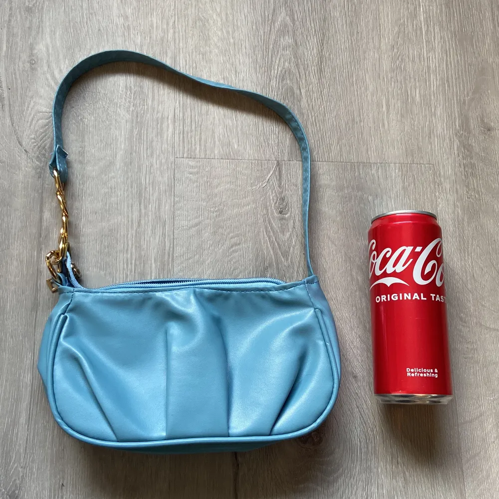 Super söt blå väska. Ganska liten så la en cola burk som perspektiv. Oanvänd. Köpt från SHEIN . Väskor.