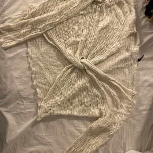 Stickad tröja från H&M - Stickad tröja med en knytning i mitten. Relativt stor i storleken