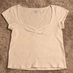 brandy melville topp - så fin vit brandy melville topp som inte kommit till användning då den är för stor för mig. så gullig halsringning  o har så fin design. köpt för några månader sedan i butik. jättefint skick. 