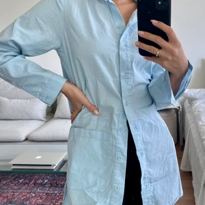 Blå poplinskjorta - ❣️Blå poplinskjorta i längre modell som går att använda som klänning eller coverup över bikinin på stranden❣️Storlek: 34 ❣️Skick: använd endaste par gånger❣️