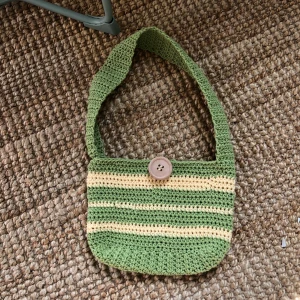 Virkad handväska - Säljer en jättesöt väska som jag virkat själv! Gön med vita ränder med en träknapp på.  Säljer även i andra färger på beställning 🥰