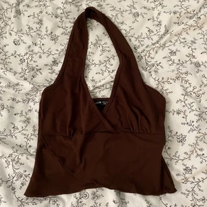 y2k topp - brun halternecktopp med omlottdesign! passar nog så bra till ett par lågmidjade jeans😩 aldrig använd! skriv gärna privat för frågor eller fler bilder!🫶