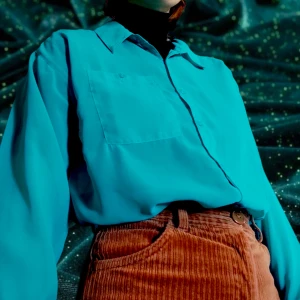 Turkos skjorta/blus - Tunn skjorta/blus i polyester. Köpt begagnad men använd väldigt lite. Har små "stretch marks" på sig, men de syns knappt när man har på sig den. Men skickar bild om du vill. 