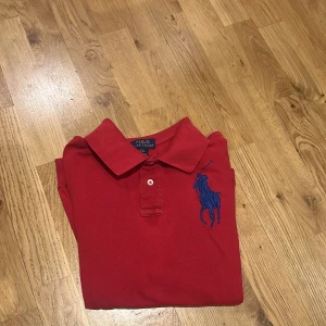 Polo Ralph Lauren  - Röd långärmad piké i gott skick. Använd några gånger men blev för liten.