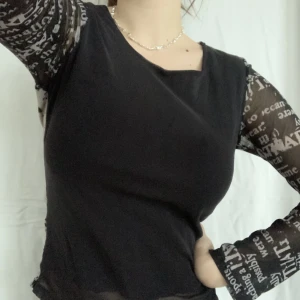långärmad mönstrad mesh topp - en svart, långärmad meshtopp med coolt text-mönster *~* fram- och baksidan har ett extra lager tyg under. fint skick men lappen är bortklippt så jag vet varken storlek eller märke. uppskattar till s-m.  bara att skriva i chatten för frågor:-*