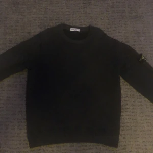 stone island tröja mörk grå - Denna tröjan är lite över 10 år gammal. Den är ovanlig för att det är en gammal modell. Den är lite utvättad så färgen har tappats lite men det är knappt märkbart annars finns det inga tecken på slitage så som fläckar eller hål på tröjan. *Tröjan är äkta*