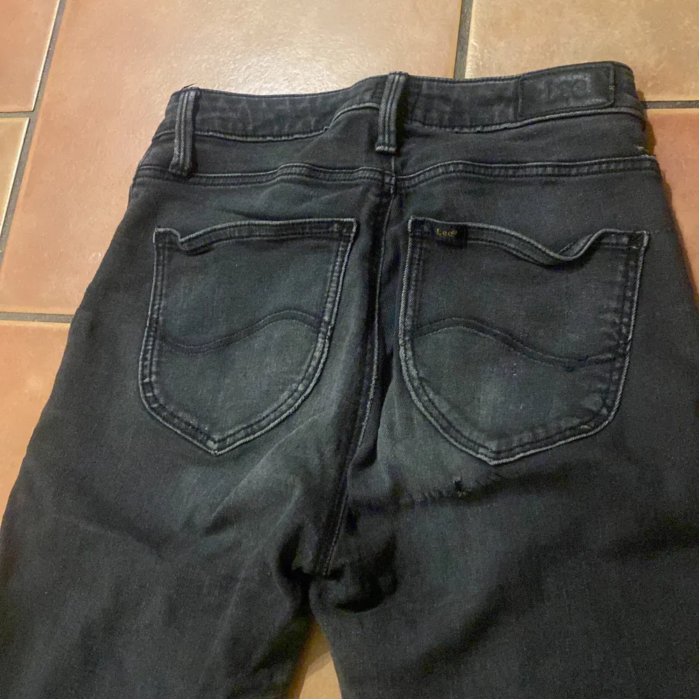 Svarta Lee jeans i en storlek W27 L33 Dessa svarta Lee jeans är i ett bra skick förutom de lilla håll bak i rumpan på byxorna som syns på sista bileden💖 finns inga andra skavanker på de💕 . Jeans & Byxor.