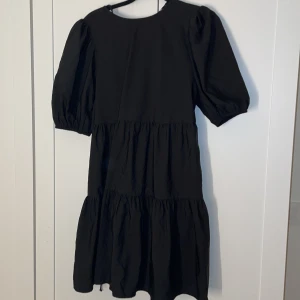 Svart klänning - Svart volang klänning från Zara i storlek S. Öppen i ryggen med knytning, aldrig använd då den ej passade, kan tänkas byta mot en större!🖤
