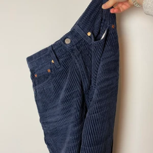 Manchester byxor från Levis - Marinblå, vida Manchester byxor från Levis. Modell: Ribcage Wildleg De är uppsydda då de var för låna till mig, men tyget finns kvar då de går att förlänga igen. Köparen står för frakten Storlek: W25 L34 Nypris: 1000kr