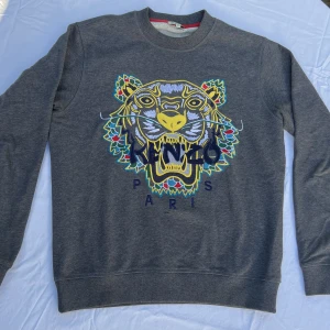 Kenzo sweatshirt - Mörkgrå dragon tiger sweatshirt från Kenzo i strl. XS.  9/10 cond; som ny, knappt använd. Nypris 2600kr, kvitto finns.
