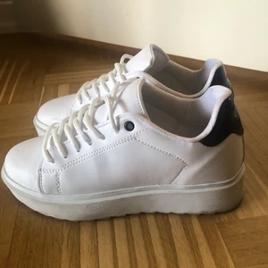 Vita sneakers med svart detalj - Vita sneakers med svart detalj från Nelly shoes. Storlek 37. Använda 1 gång. Sista bilden är lånad från Nelly.com
