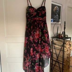 Klänning AX passar 38  - Fin klänning , svart botten. AX strl 10, passar en 38. Använd några ggr. Kortare fram och full längd bak. Lätt vadderade kupor. Resårsmock bak= sitter bra! Nypris 600kr. 