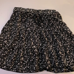 Svart blommig kjol - Svart blommig kjol perfekt till sommaren. Går att knyta som syns på andra bilden.