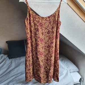 Klänning från H&M - Säljer en fin mörkröd- och beigeblommig klänning från en gammal H&M-kollektion i storlek 38. Passar fint med en tröja under som på sista bilden. Frakt ingår ✨️
