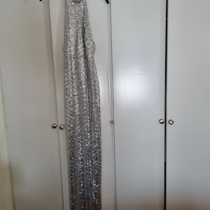 Storlek 38 - En fin paljetter  klänning i färgen silver använd en gång vid ett tillfälle och ät köpt på nelly. Köparen står för frakten kan skicka fler bilder om de behövs. Jag är 163 och den är lite för lång för mig😀