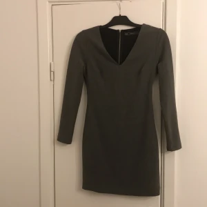 Grå klänning strl M - Grå tight klänning strl M från Zara, dock liten i strl passar en S. Fina detaljer med delvis öppen rygg.