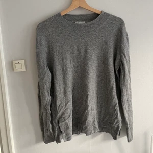 Grå cashmere H&M - Grå cashmere H&M 100% cashmere, slitsar vid sidorna något utställd. Fint skick, storlek medium, knappt använd!