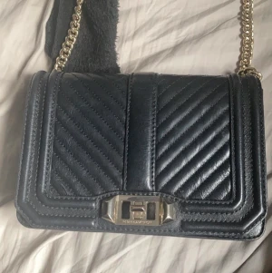 Rebecca Minkoff väska  - Säljer min Rebecca Minkoff CHEVRON QUILTED SMALL LOVE - Axelremsväska, självklart äkta . Den är köpt för 2500kr. Är även öppen för byten. Om du har några frågor tveka inte på att fråga.💕💗