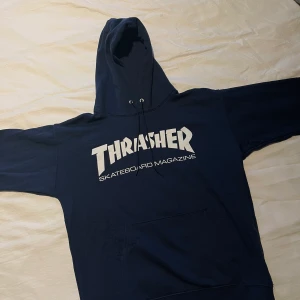 Thrasher hoodie storlek S, NY! - Thrasher hoodie i storlek Small. Färg: Marinblå. Inköpt hos Junkyard förra året, färgen finns inte att köpa längre. Använd Max 2 gånger, så i nyskick!   Nypris hos Junkyard är 1249:-   Djur finns i hemmet, rökfritt hem.