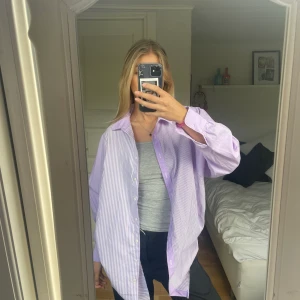 Mönstrad skjorta  - Oversized skjorta i lila och vit. Olika typer av ränder på sidorna. Så fin till typ stranden eller bara till jeans! 