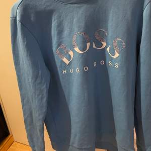 Säljer ljusblå Hugo Boss sweatshirt.  Storlek M men passar även storlek S.  Använt endast i 2 veckor, bra skick. 