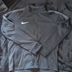 Nike M (10-12år) - Nike träningströja med dragkedja och fickor i fint skick