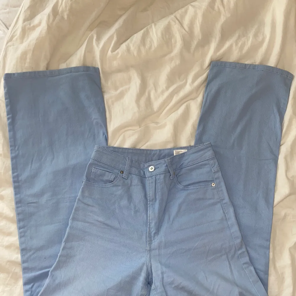 Klarblåa högmidjade jeans från H&M! Är i fint skick, endast två små vita prickar längst ner på ena benet, de sista bilden! Supersköna!. Jeans & Byxor.