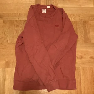 Levi’s Troja i färg röd.  - Levi’s tröja i färgen röd. Har använts fåtal gånger. Storlek S. Mötas gärn upp i centrala Stockholm. Kan diskutera priset. 