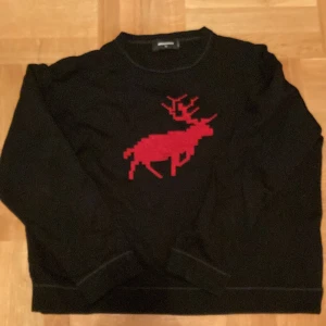 DSQUARED2 tröja. - DSQUARED2 töja i färgen svart med en röd älg på. Har använts fåtal gånger. Tröjan har tyvärr blivit tvättad för liten så passar S/M i storlek. Möts gärna upp i Stockholm city. 