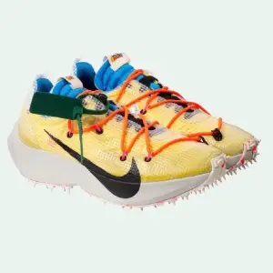 Off WhiteX Nike Vapor Street Off-White™ x Nike Vapor Street in yellow. Nylon and synthetic material overlay and hiking-inspired lace-up closure in orange. Black lace-up closure. White spiked sole. Black swoosh at one side and silver swoosh at other side.