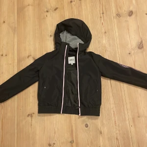 Vindjacka Barn - Svart och rosa vind jacka i storlek 134, helt ny bara använd 2 gånger.