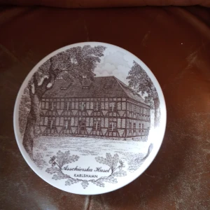 Jubelium 300 år av Asschierska huset Karlshamn . Gustavsberg . - Fin tallrik Asschierska huset Karlshamn jubelium 300 år av märket Gustavsberg och i begränsad upplaga . 22cm stor. Hämtas i Skene alt skickas o köpare betalar frakten o Swishbetalning tillämpas .frakt inräknat i priset .104 kr .