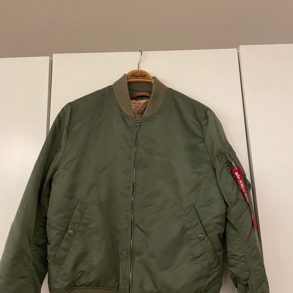 En grön bomberjacka som inte används längre, hängt i garderoben de senaste åren den användes en höst för något år sen. . Jackor.