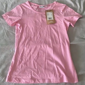 Rosa t-shrit  - Säljer denna t-shirten i storlek XS, prislappen sitter fortfarande på, har aldrig använt denna och vill bara bli av med den så fort som möjligt! Använd inte köp nu funktionen utan skriv till mig om du vill köpa eller har frågor. Frakt tillkommer! 