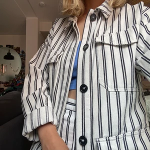 Randigt svartvitt set - Ett par randiga brallor med snygg söm i rumpan med matchande kavaj/jacka från Monki. Sparsamt använt.