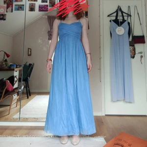 Finklänning ljusblå - Originellt från H&M, men köpt från Röda Korset för 100 kr. Klänningen är endast testad, aldrig använd, och i perfekt skick vad jag kan se. Jag använde den aldrig då den är för kort för mig, jag (inkl klackarna) är 180 cm lång och klänningen hänger ca 15-20 cm över marken. Färgen och överdelen av klänningen syns lite tydligare på sista bilden. Eftersom klänningen ser bra ut och jag aldrig använt den säljer jag den för 90 kr. 