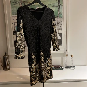 Paljettklänning - Snygg paljettklänning, figursydd vid höfterna. Bara provad en gång. Svart och guld färgad
