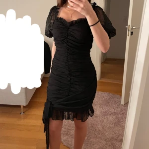Meshklänning i svart - Meshklänning i svart med puffärmar och knytning framtill. Sitter superfint på kroppen. Köpt ifrån Boohoo och är i storleken 36. 