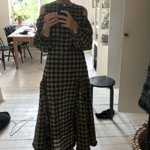 Ganni klänning rutig - Ovanlig klänning från Ganni med cut-outs vid axlarna och osynlig zip framtill. Just denna modellen är superovanlig. 