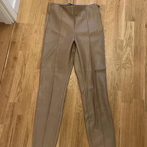 Brun / beige skinnbyxor Zara - Säljer dessa beige / bruna skinnbyxor i M från Zara men passar även mig är mer en XS - S. Dragkedja på sidan. Stupraka ben. Nyskick. Säljer för 160 kr. Köparen står för frakten! 