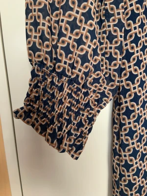 Knälång klänning  - Mönstrad klänning, bra skick, okänd varumärke. 