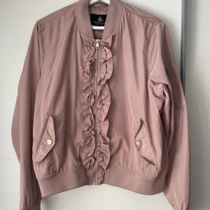 Rosa vårjacka - Säljer en tunn rosa vårjacka, använd mycket. Har detaljer framtill vid kedjan. Köpt på gekås, märket är Magiano. Strl L❤️