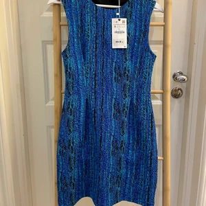 Zara - blå strukturklänning - Jättesnygg klänning från zara i struktur. Stretchigt material och normal i storleken. Helt oanvänd, nypris 399:- säljes för 299:- köparen står för frakten.