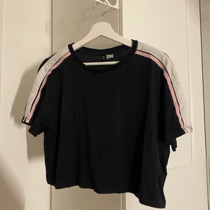 T-shirt svart/vit/rosa  - Säljer denna gripande t-shirt med rosa & vitt på axlarna ifrån H&M