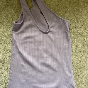 Cross iver linne  - Ett helt oanvändt linne i lila som enbart sitter över ena axeln! Tyvärr ingen lapp kvar, men aldrig använd. Storlek xs