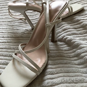 Vita högklackade skor i strlk 39 - Säljer dessa fina klassiska vita högklackade skor från märket RAPID i strlk 39, dem är åtsittande och tighta i strlk. Använda enbart 1 gång.